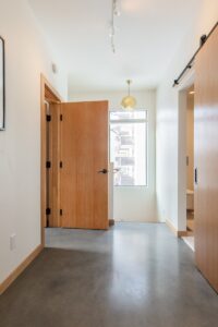 brown wooden door near white wall